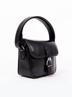 Flat lay of a small premium bridle butt navy leather crossbody Faith hand bag that has been hand stitched in England with 1 front facing buckle strap and the back embossed with Newmarket 875 horse logo.