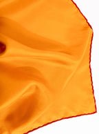 Flat lay of 100% silk 40x40 hank scarf in gold yellow with red hand stitched border. 
