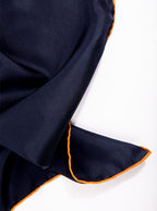 Flat lay of 100% silk 40x40 hank scarf in navy with gold yellow hand stitched border. 