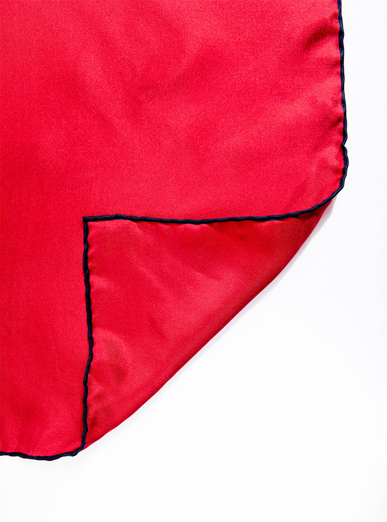 Flat lay of 100% silk 40x40 hank scarf in red with navy hand stitched border. 