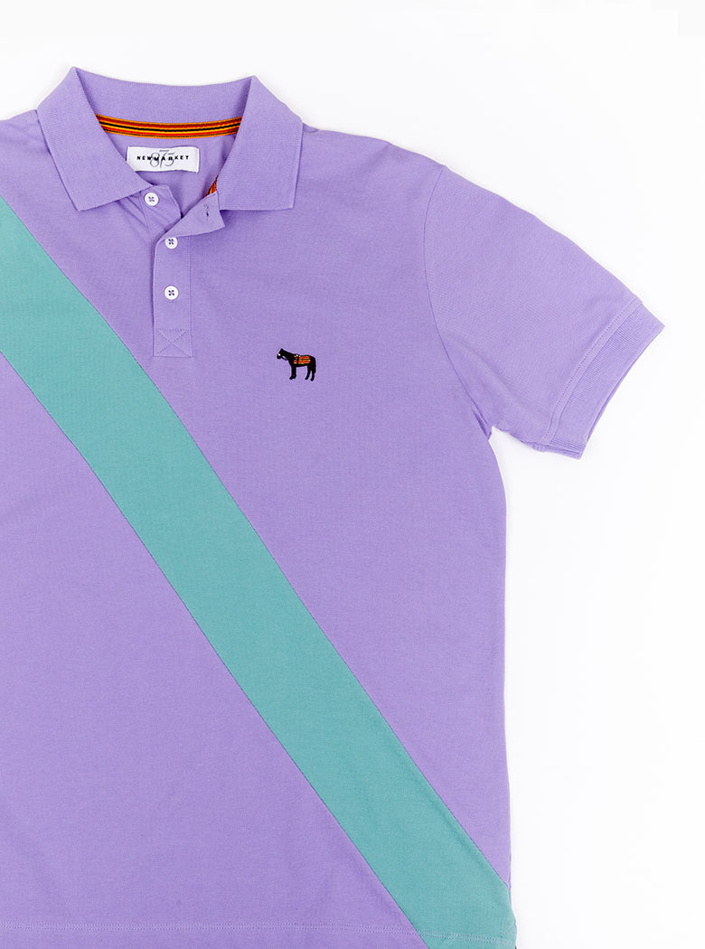 Flat lay of lilac 100% cotton polo shirt with avocado green sash detail and Newmarket 875 horse logo embroidered on the front.