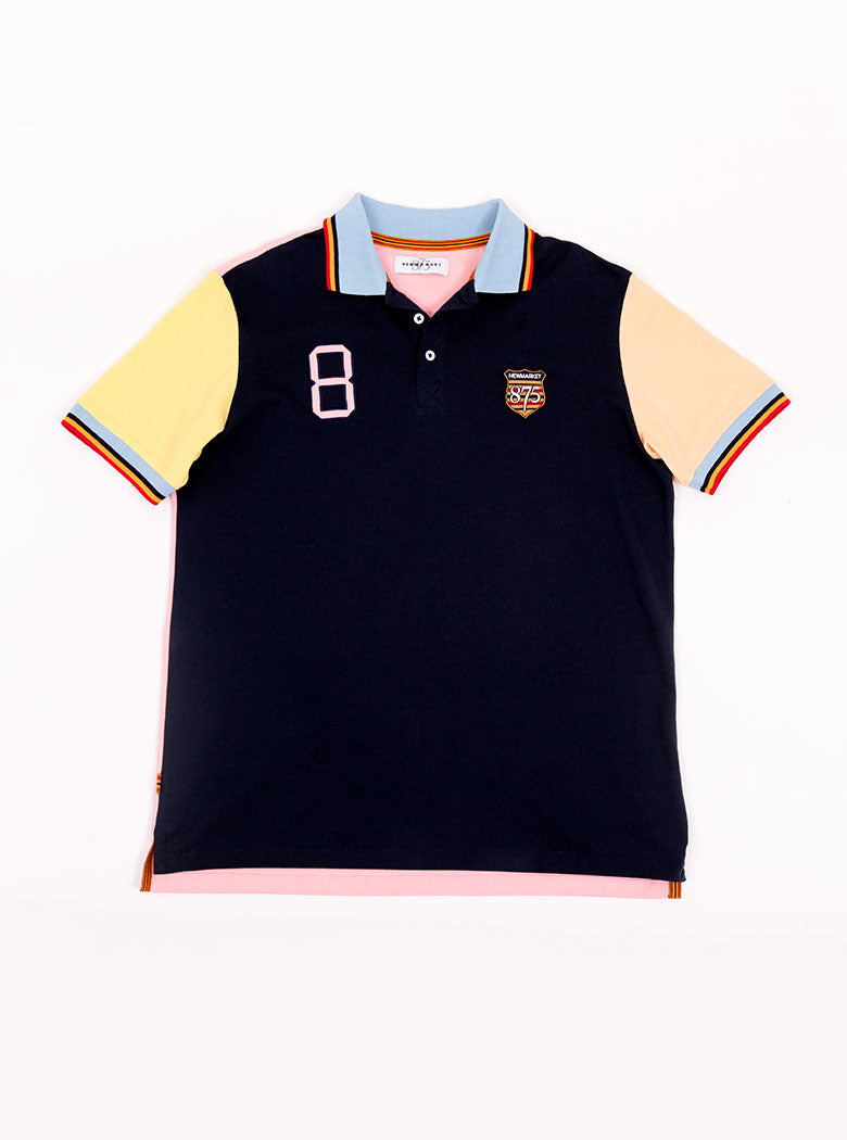Man wearing navy based multicoloured panelled 100% cotton polo shirt with giant number 8 on pale pink back.