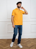 Man wearing gold yellow polo shirt in 100% cotton with Newmarket 875 horse logo embroidered on the front.