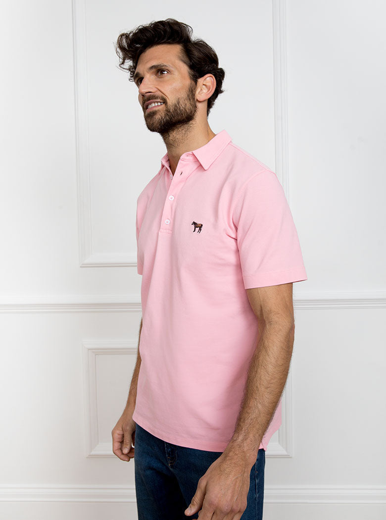 Man wearing pale pink polo shirt in 100% cotton with Newmarket 875 horse logo embroidered on the front.