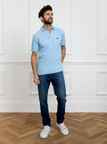 Man wearing sky blue polo shirt in 100% cotton with Newmarket 875 horse logo embroidered on the front.