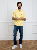 Man wearing lemon yellow polo shirt in 100% cotton with Newmarket 875 horse logo embroidered on the front.