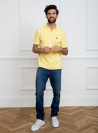 Man wearing lemon yellow polo shirt in 100% cotton with Newmarket 875 horse logo embroidered on the front.