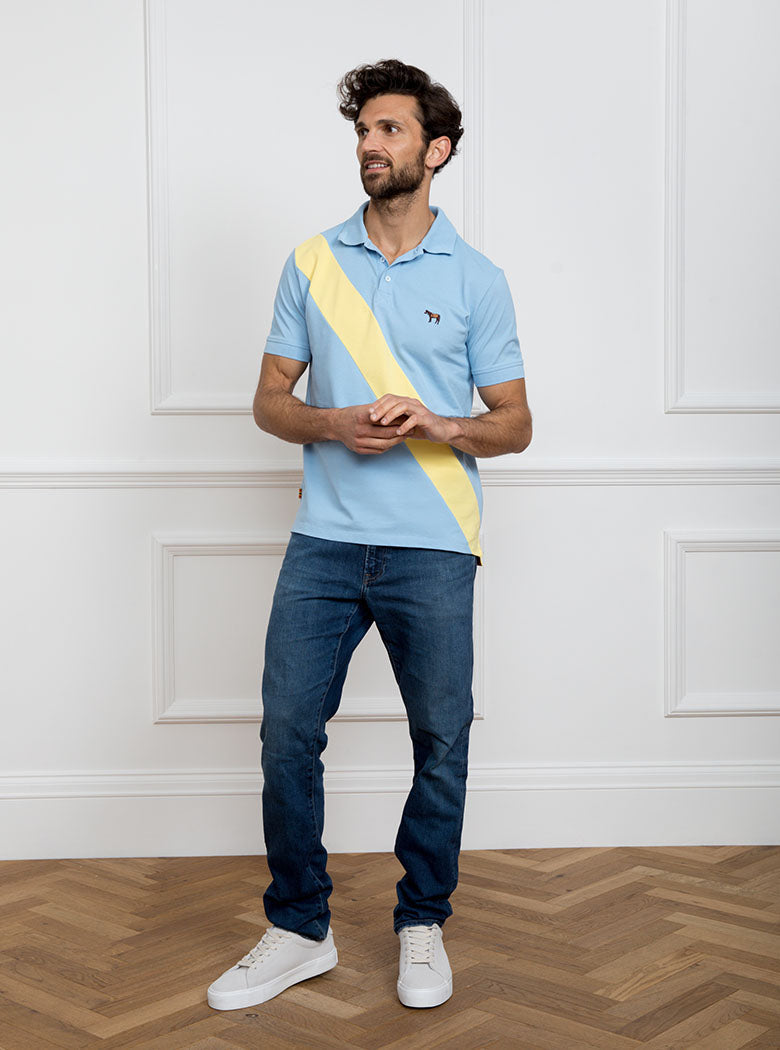 Man wearing sky blue 100% cotton polo shirt with lemon yellow sash detail and Newmarket 875 horse logo embroidered on the front.