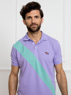 Man wearing lilac 100% cotton polo shirt with avocado green sash detail and Newmarket 875 horse logo embroidered on the front.