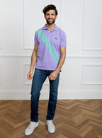 Man wearing lilac 100% cotton polo shirt with avocado green sash detail and Newmarket 875 horse logo embroidered on the front.