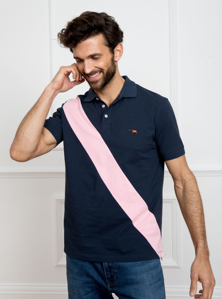 Man wearing navy 100% cotton polo shirt with pale pink sash detail and Newmarket 875 horse logo embroidered on the front.