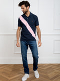 Man wearing navy 100% cotton polo shirt with pale pink sash detail and Newmarket 875 horse logo embroidered on the front.