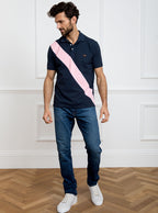 Man wearing navy 100% cotton polo shirt with pale pink sash detail and Newmarket 875 horse logo embroidered on the front.