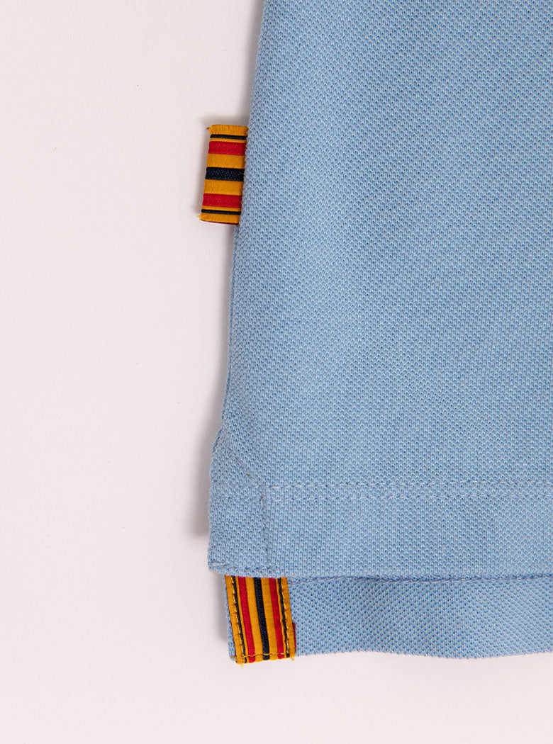 Close up flat lay of mens 100% cotton polo in a sky blue colour with the Newmarket 875 brand tag.