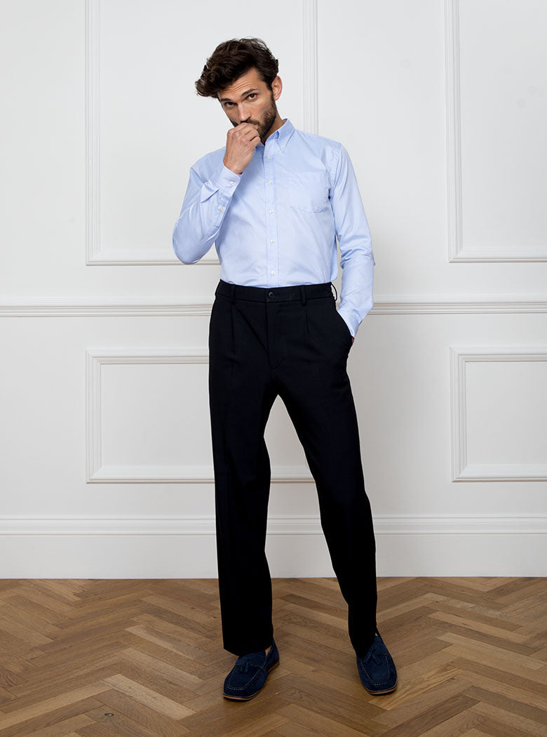 Man wearing a sky blue long sleeved shirt with a button down collar made with 100% Royal Oxford Cotton.