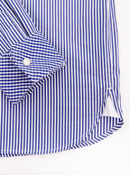 Flat lay of men's long sleeved shirt with navy blue thin stripe and gingham cuff and collar pattern on the inside. Made with 100% cotton in Thomas Mason fabric.