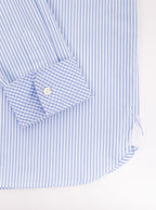 Flat lay of mans long sleeved shirt in thin stripe sky blue and white print with inside of collar and cuff in gingham pattern. Made with 100% cotton in Thomas Mason fabric.