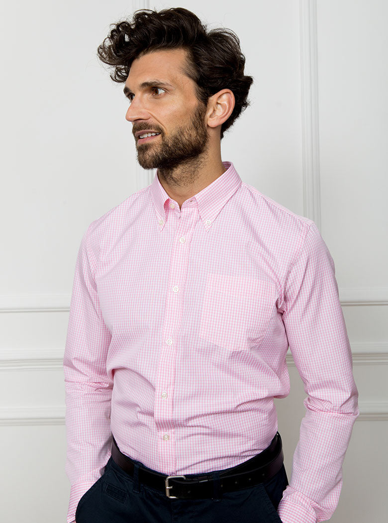 Man wearing a pale pink long sleeved shirt in a gingham pattern made with 100% cotton in a Thomas Mason fabric.
