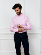 Man wearing a pale pink long sleeved shirt in a gingham pattern made with 100% cotton in a Thomas Mason fabric.