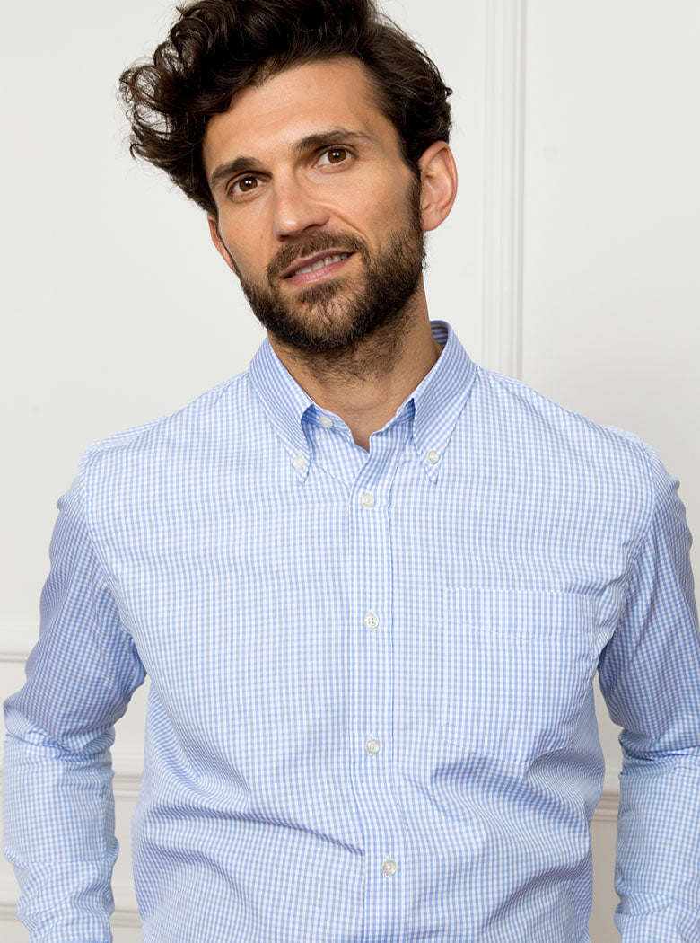 Man wearing sky blue long sleeved shirt in a gingham pattern made with 100% cotton in a Thomas Mason fabric.