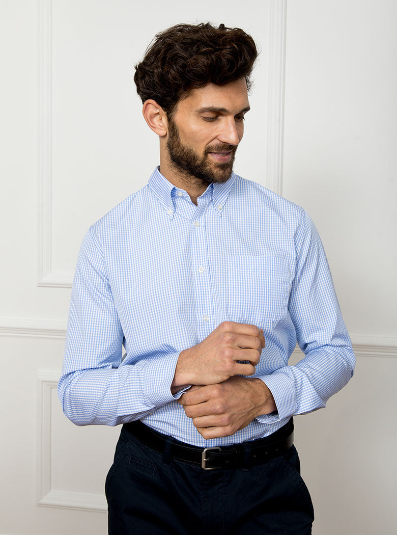 Man wearing sky blue long sleeved shirt in a gingham pattern made with 100% cotton in a Thomas Mason fabric.