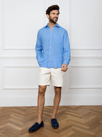 Man wearing a sky blue long sleeved shirt with pocket detail made with 100% linen in a Thomas Mason fabric.