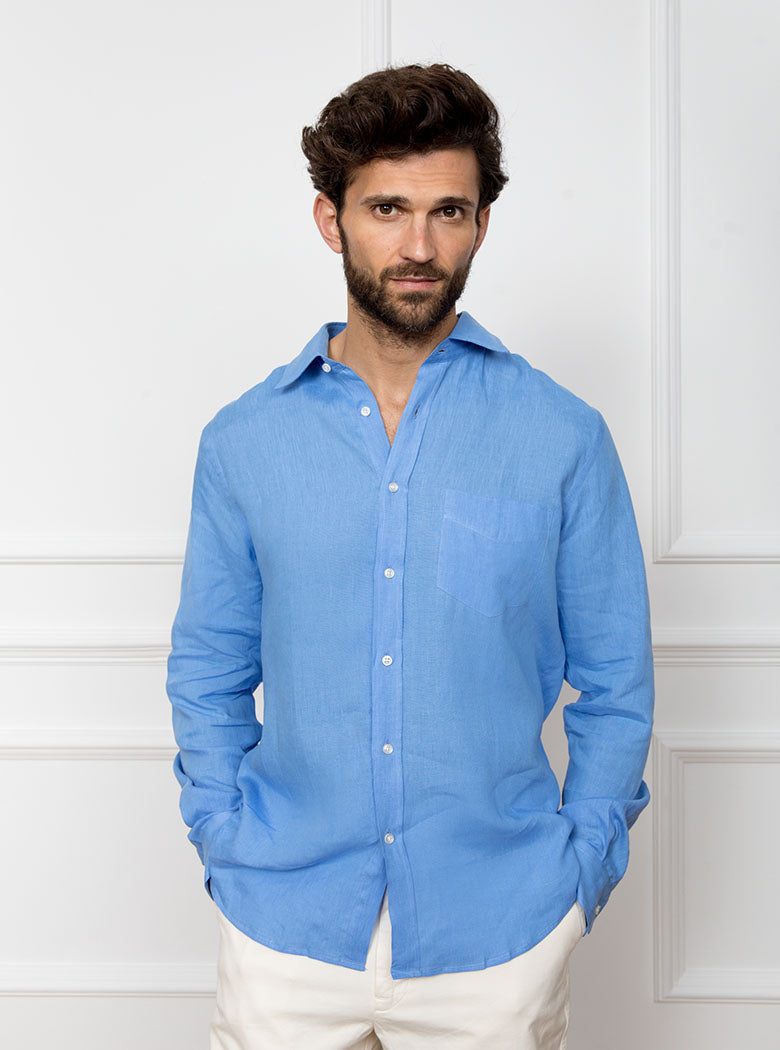 Man wearing a sky blue long sleeved shirt with pocket detail made with 100% linen in a Thomas Mason fabric.