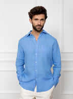 Man wearing a sky blue long sleeved shirt with pocket detail made with 100% linen in a Thomas Mason fabric.