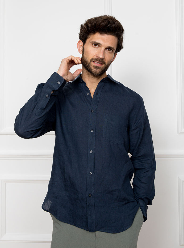 Man wearing a navy blue long sleeved shirt with pocket detail made with 100% linen in a Thomas Mason fabric.
