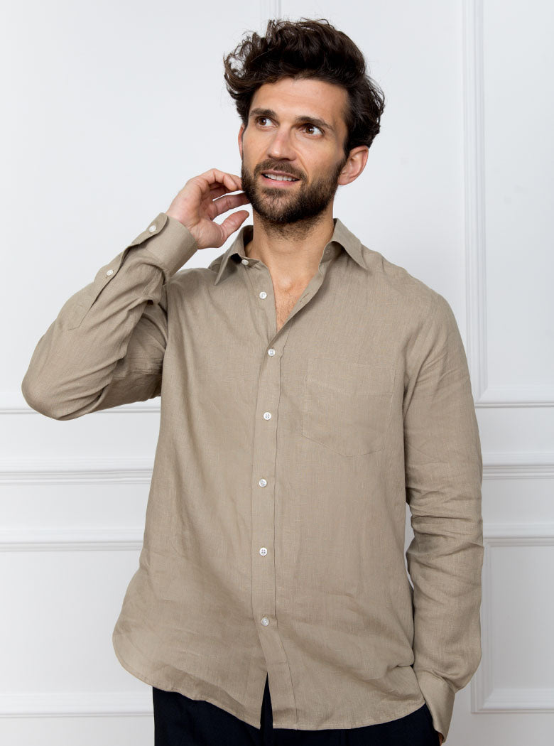Man wearing a tan long sleeved shirt with pocket detail made with 100% linen in a Thomas Mason fabric.