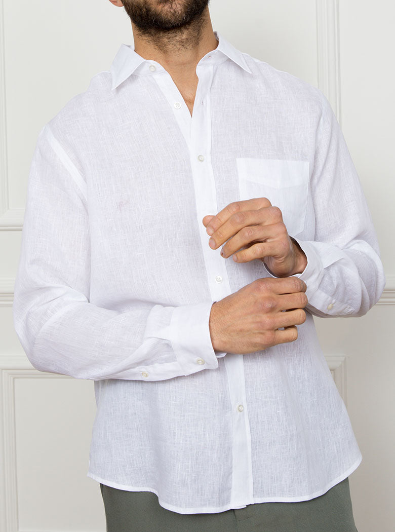 Man wearing white long sleeved shirt with a pocket detail made with 100% linen in a Thomas Mason fabric.