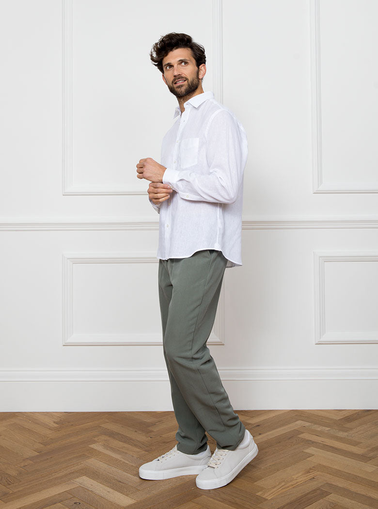 Man wearing white long sleeved shirt with a pocket detail made with 100% linen in a Thomas Mason fabric.