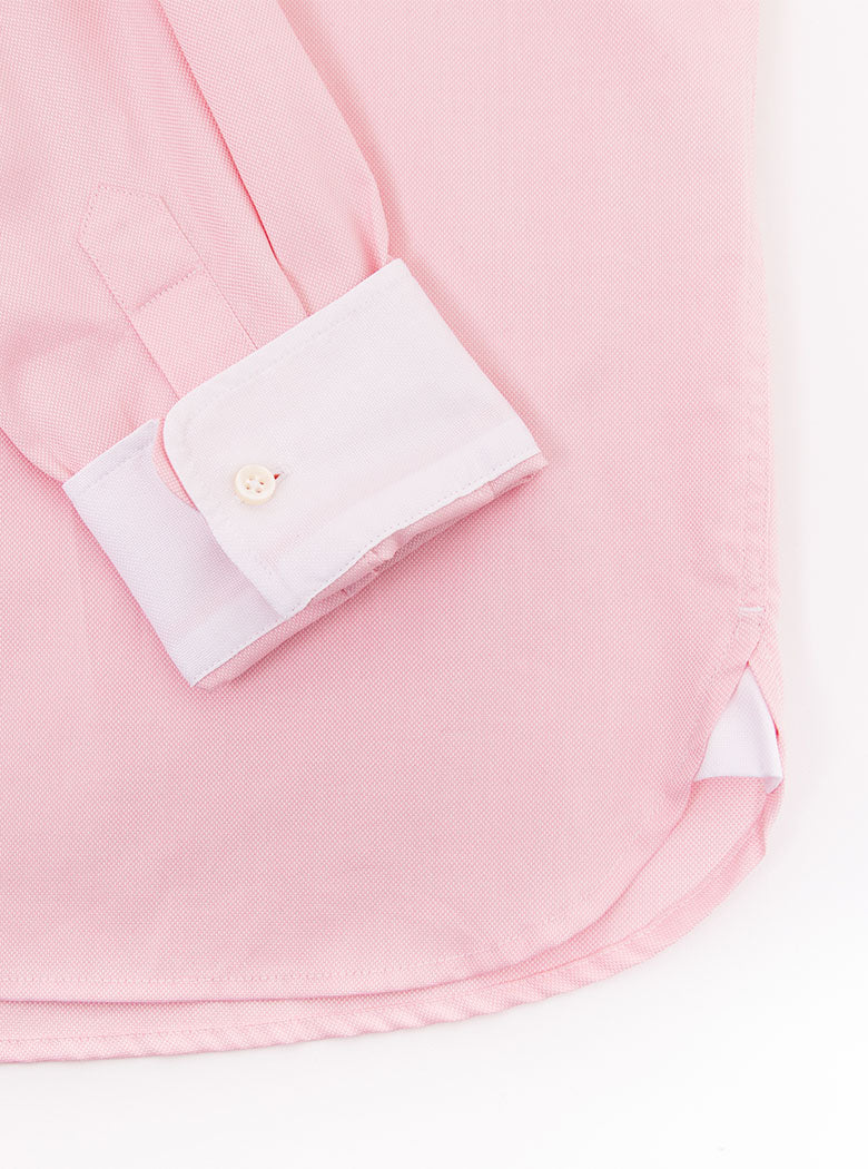 Flat lay of men's pale pink long sleeved shirt with a button down collar made with 100% cotton in a Thomas Mason fabric.