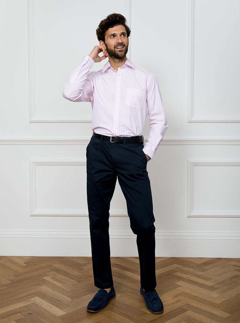 Man wearing long sleeved shirt with pale pink and white stripe made with 100% cotton from Thomas Mason.