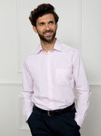 Man wearing long sleeved shirt with pale pink and white stripe made with 100% cotton from Thomas Mason.