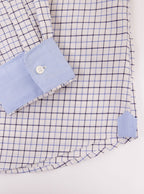 Flat lay of long sleeved shirt with tattersall blue check pattern and the inside collar and cuffs trimmed with sky blue. Made with 100% cotton in Thomas Mason fabric.