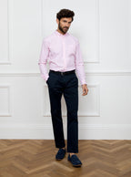 Man wearing a long sleeved shirt with a pale pink and white thin stripe pattern made with 100% Oxford in a Thomas Mason fabric.