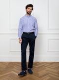 Man wearing long sleeved shirt with royal blue and white thin stripe made with 100% cotton from Thomas Mason.