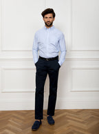 Man wearing long sleeved shirt with sky blue and white thin stripe and the inside collar and cuffs trimmed with gingham pattern. Made with 100% cotton in Thomas Mason fabric.