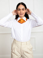 Woman wearing 100% silk 40x40 hank scarf in gold yellow with red hand stitched border. 