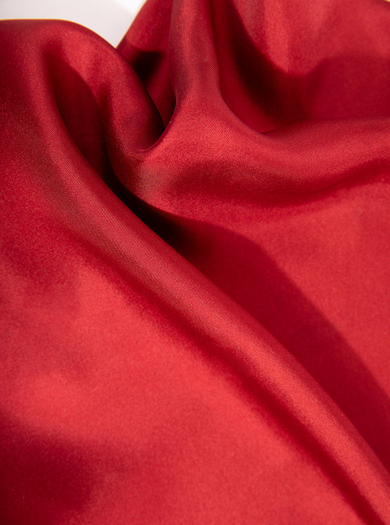 Flat lay of 100% silk 40x40 hank scarf in red with navy hand stitched border. 